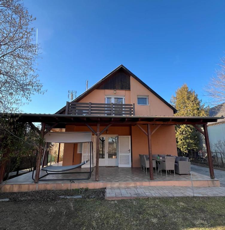 a house with a roof that has a patio at Izabella Vendégház in Balatonszárszó
