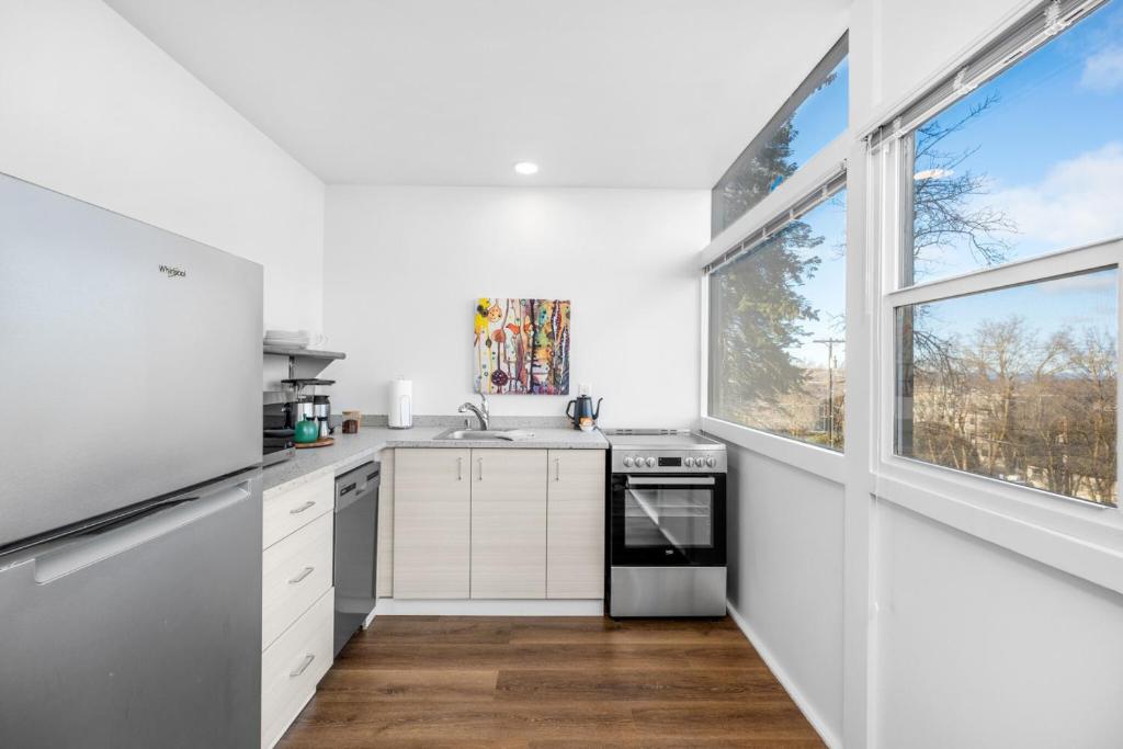 Una cocina con gabinetes blancos y una ventana grande. en Iconic Modern Stay w Free Parking, en Spokane