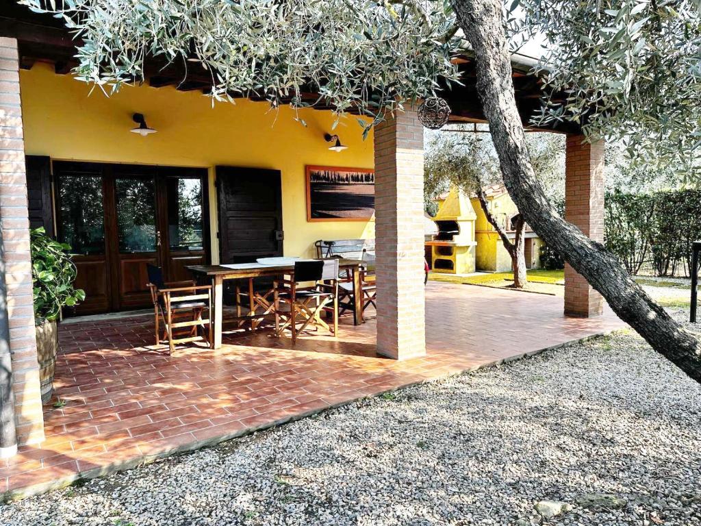 a patio with a table and chairs in front of a house at Tuscany Cottage Paratino 53 by Zoom In Earth in Cecina