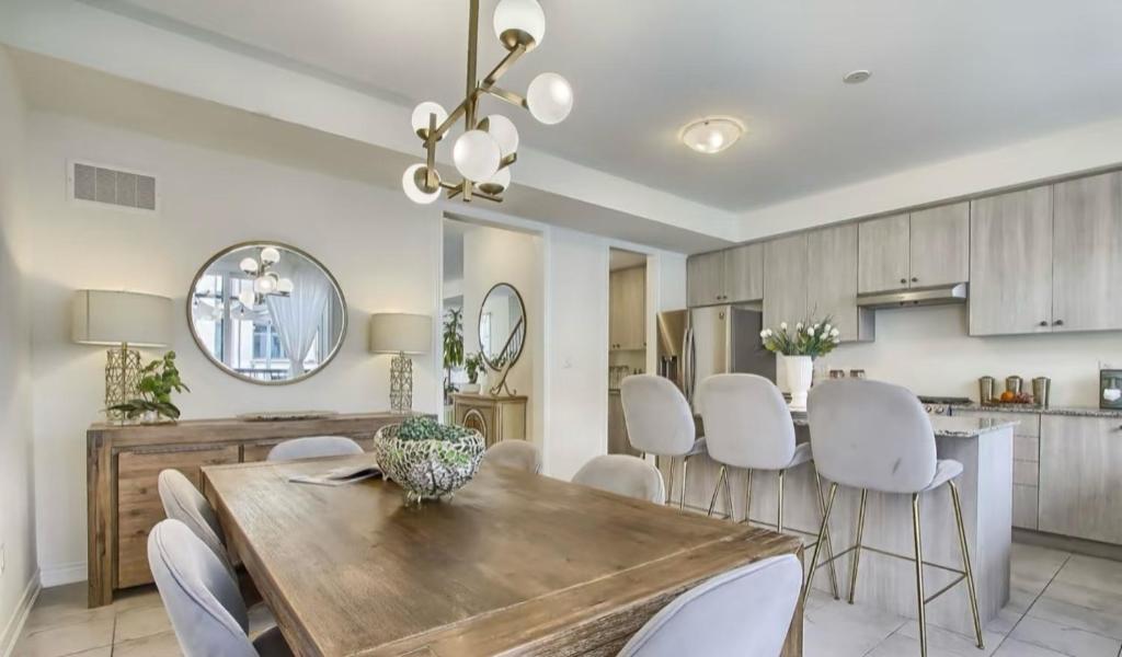 a kitchen and dining room with a wooden table and white chairs at XTO Hotel in Markham