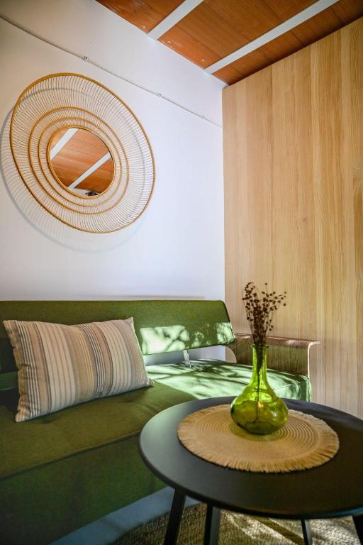 a room with a green couch and a vase on a table at antiguo gallinero in Collado-Villalba
