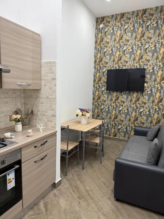 a kitchen and living room with a couch and a table at Casa del puente in Ercolano