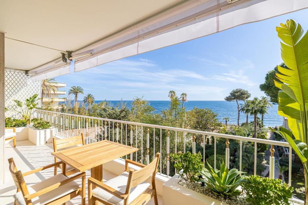 un balcon avec une table et des chaises et l'océan dans l'établissement REF 1981 - Cannes sea view apartment Cannes Palm Beach, à Cannes