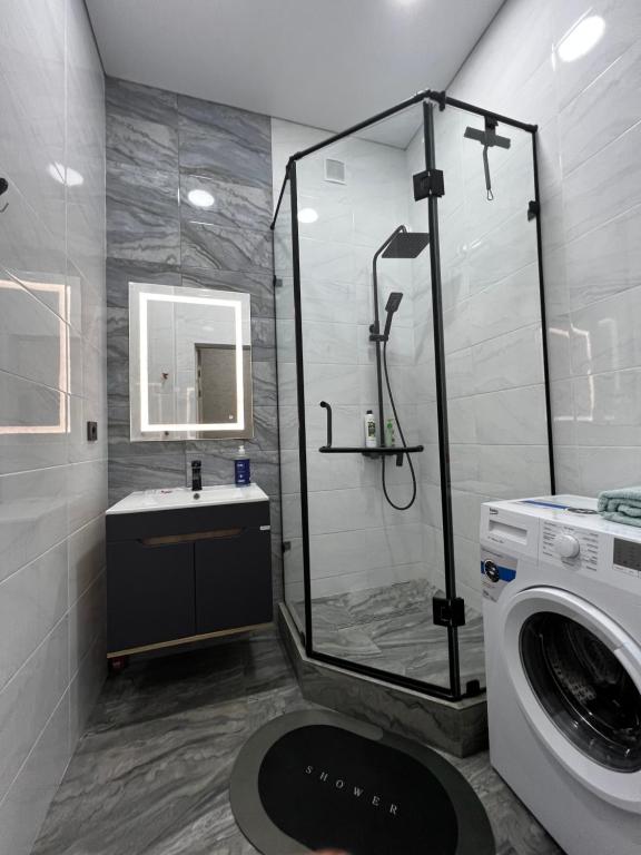 a bathroom with a shower and a washing machine at 2х комнатная квартира ЖК Арман in Kokshetau
