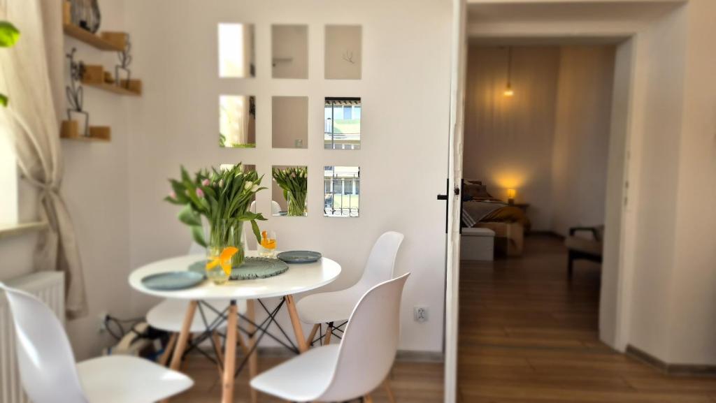 a dining room with a table and white chairs at Przemyślany Azyl in Przemyśl