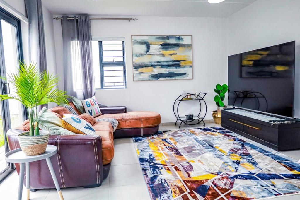 a living room with a couch and a rug at Jackal Creek Golf Estate- Luxury comfortable home in Roodepoort