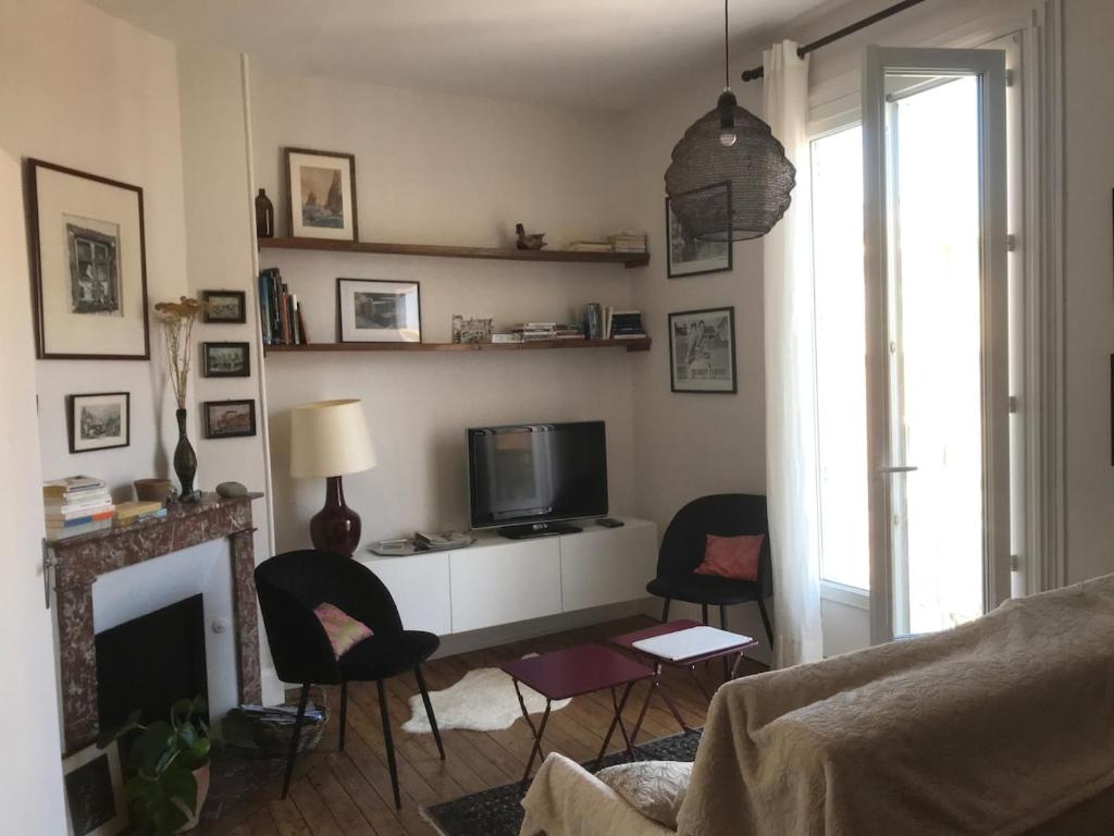 Appartement ancien cosy في دْييب: غرفة معيشة مع تلفزيون ومدفأة