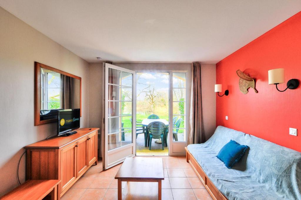 un salon avec un canapé et une télévision dans l'établissement La résidence du Lac - maeva Home - Maison 3 pièces 6 personnes - Sélection MAE-1781, à Monflanquin