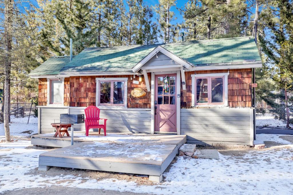 una casa pequeña con una silla roja en la nieve en Big pines #103, en Big Bear Lake