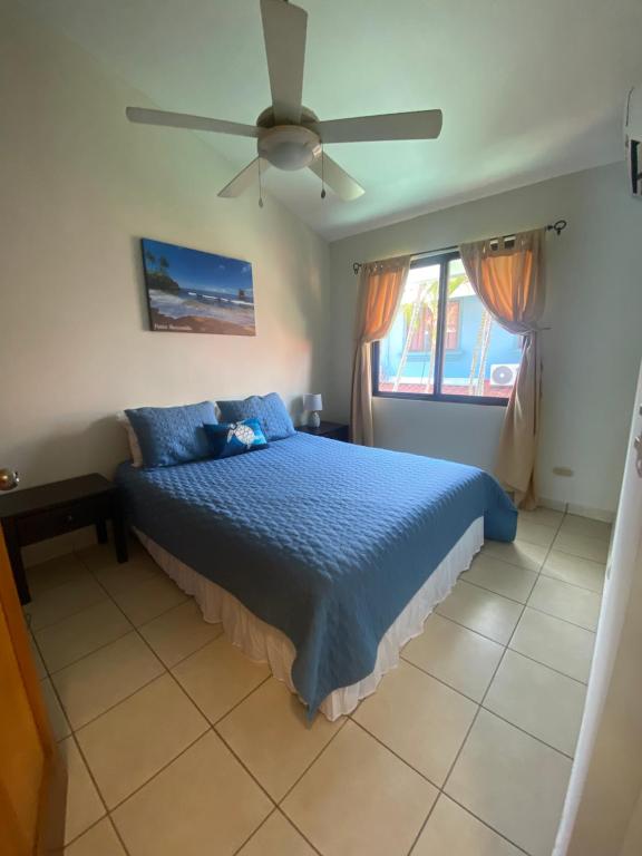 a bedroom with a blue bed and a ceiling fan at Coco Maya 2b2b Villa in Coco