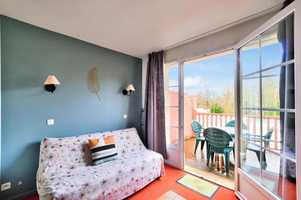 un salon avec un canapé et une grande fenêtre dans l'établissement La résidence du Lac - maeva Home - Appartement 2 pièces 4 personnes - Sélection MAE-5811, à Monflanquin