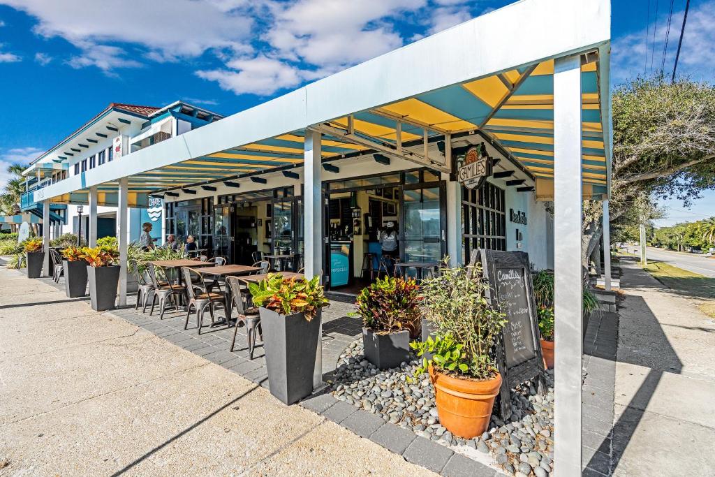 a restaurant with tables and chairs and plants on a sidewalk at Beachside Inn in Destin