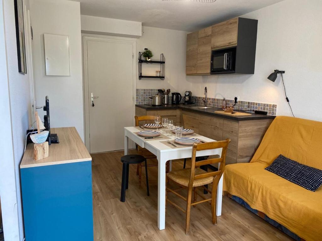 un salon avec une table et une cuisine dans l'établissement Appartement Havre de Quiberon, à Quiberon