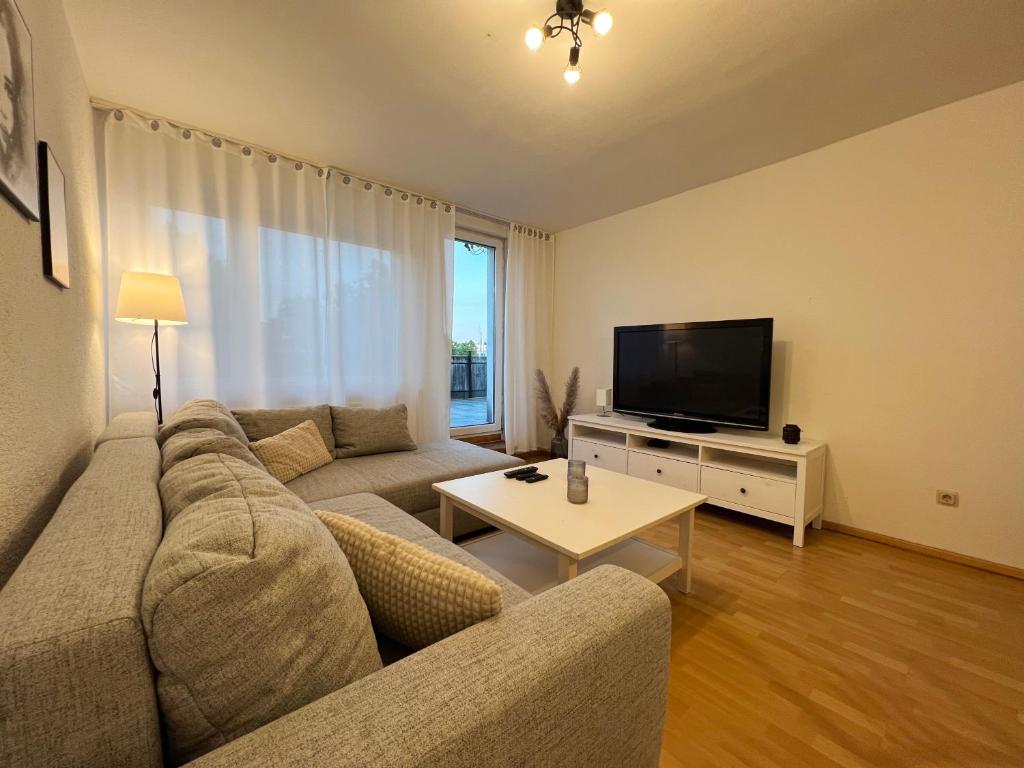 a living room with a couch and a flat screen tv at 85qm - Zentrale Lage - Parkplatz in Göttingen