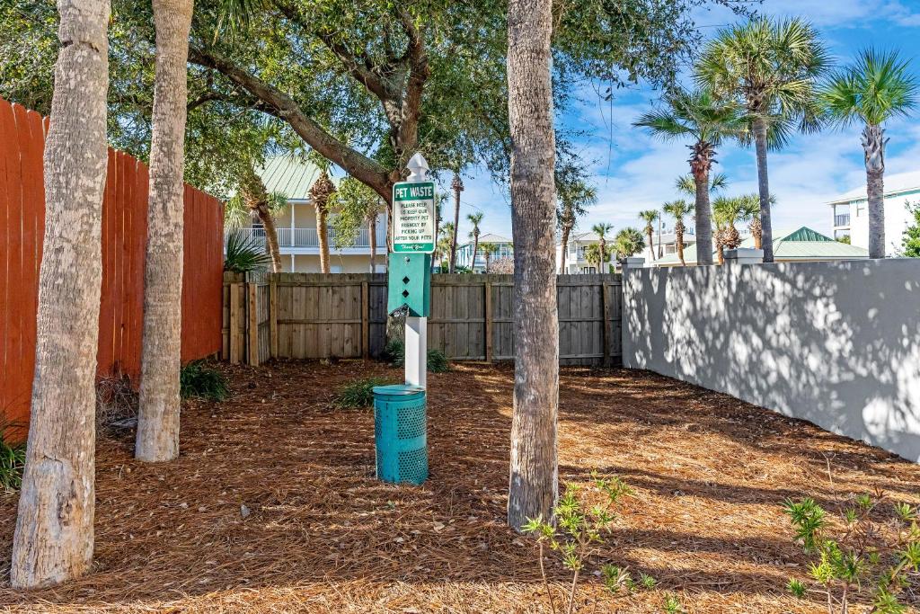 a street sign in front of a fence with trees at Beachside Inn in Destin
