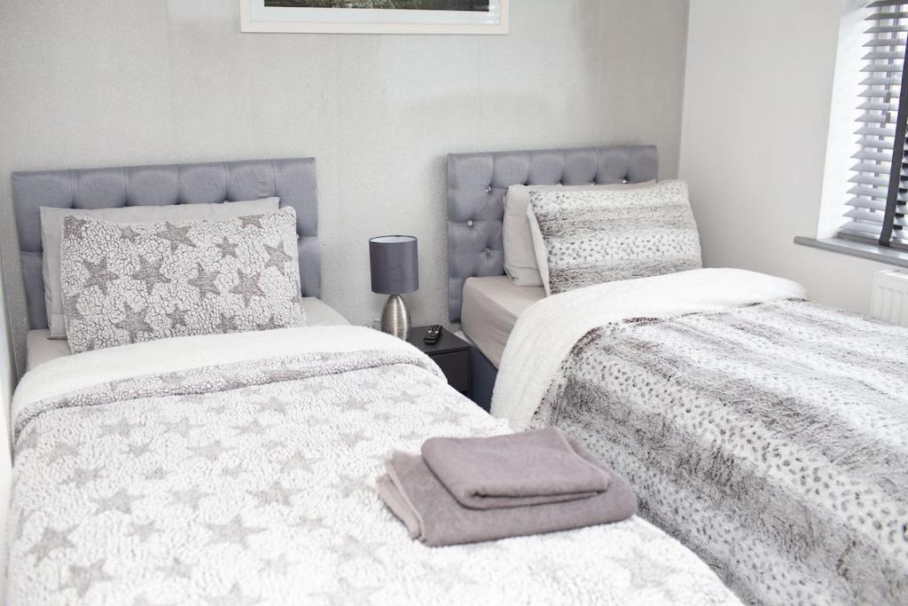 a bedroom with two beds with towels on them at The Grey Mansion in Manchester