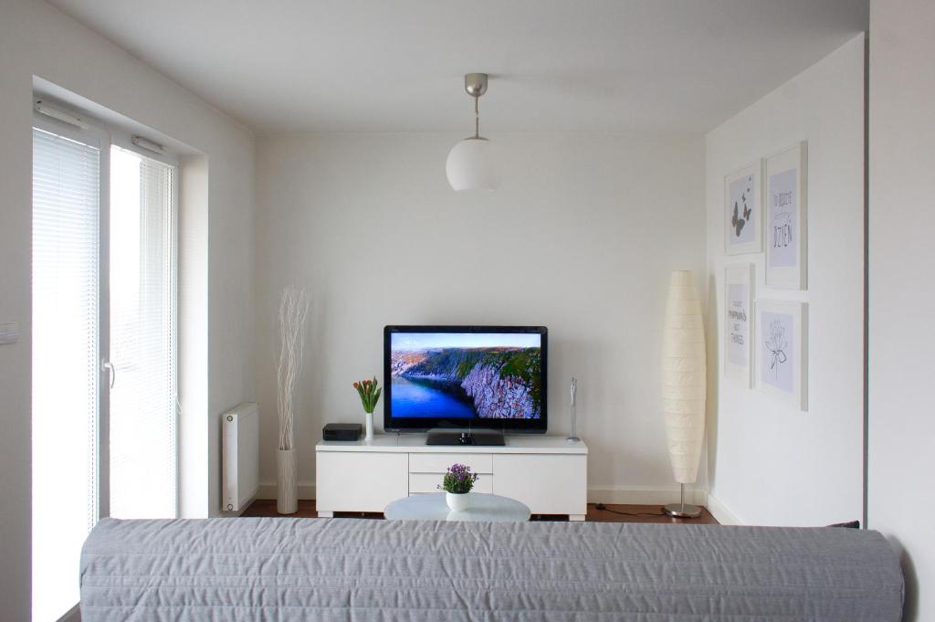 a bedroom with a bed and a tv on a white cabinet at Apartament-31 in Gdańsk