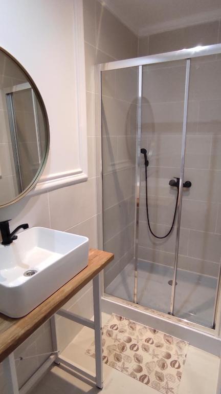 a bathroom with a shower with a sink and a mirror at Wrzosowy Zakątek in Tuczno