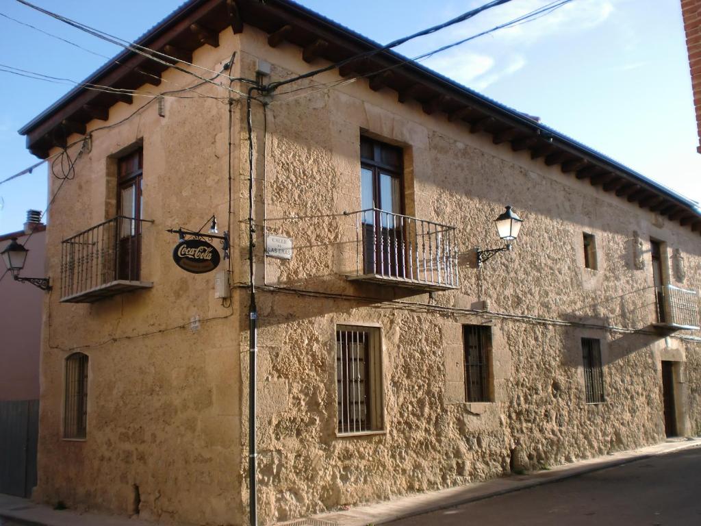 un edificio con 2 balcones y una señal en él en La Posada de Pesquera, en Pesquera de Duero