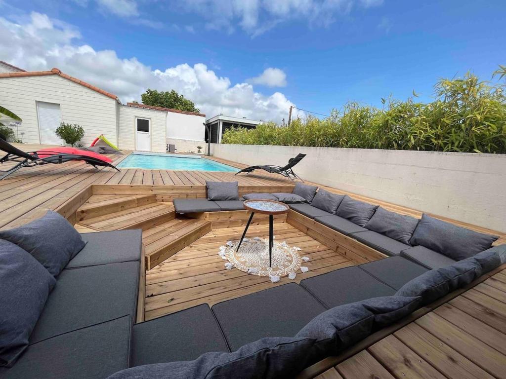 une terrasse avec un canapé, une table et une piscine dans l'établissement Villa Longeville avec Piscine Chauffée, à Longeville-sur-Mer
