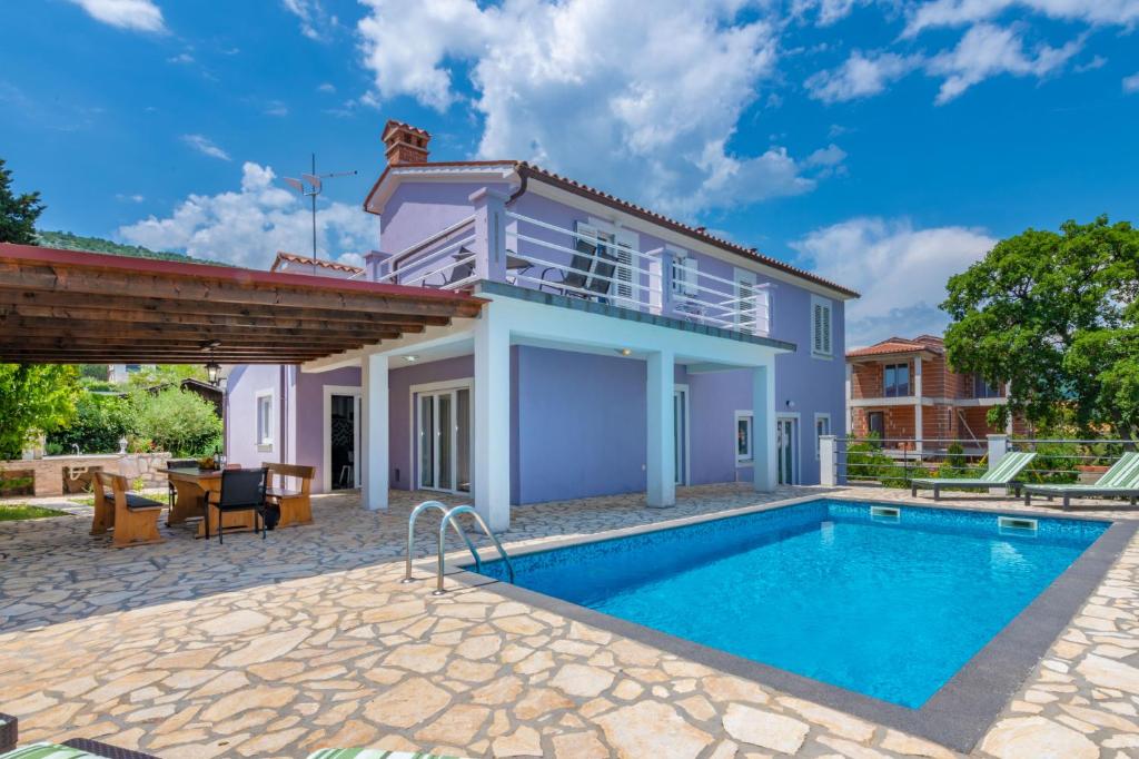 una villa con piscina y una casa en Villa Sandra, a beautiful villa with sea view and a pool, en Drenje