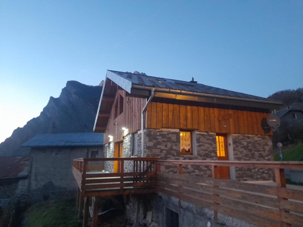 a house with a wooden balcony in front of it at chalet la Dalle in Saint-Martin-de-la-Porte