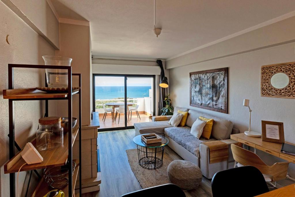 a living room with a couch and a table at Apartamento Amara in Carvoeira