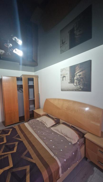 ein Schlafzimmer mit einem Bett und einem Bild an der Wand in der Unterkunft Apartament Faleza Tiglina in Galaţi