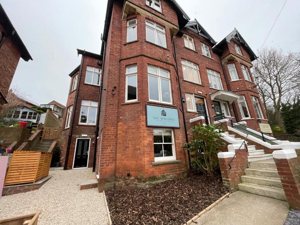 a red brick building with a sign on it at The Willows Boutique Stays by i-Stay Whitby in Whitby