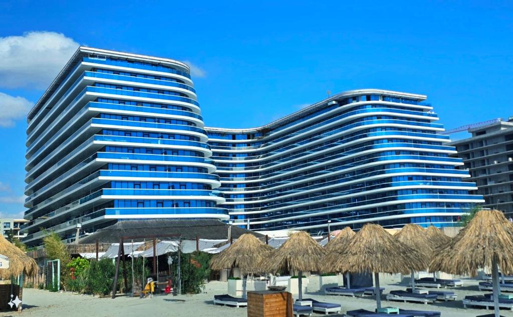 a large building with a beach in front of it at White Titanic 322 in Mamaia Nord