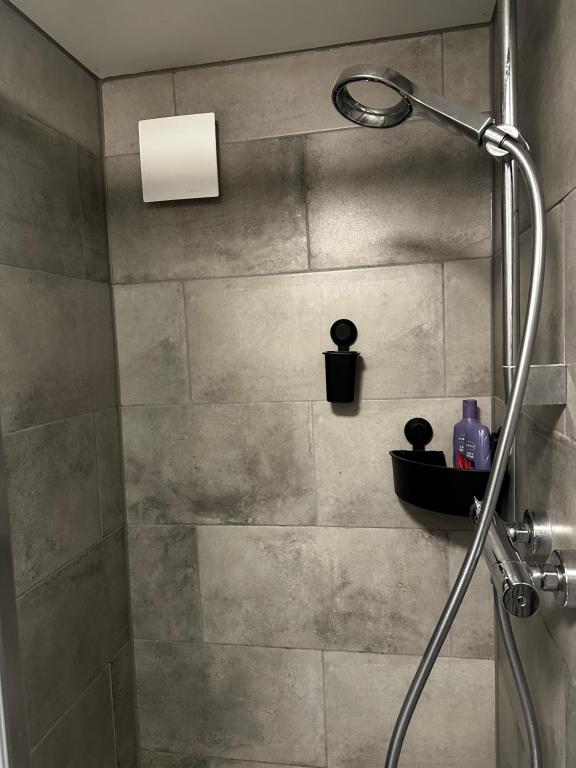 a shower with a shower head in a bathroom at Garden house, Free parking in Zandvoort