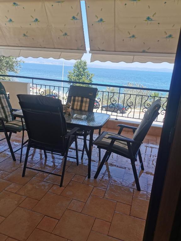 a patio with a table and chairs and a view of the ocean at Endless blue apartment kassandra in Nea Fokea