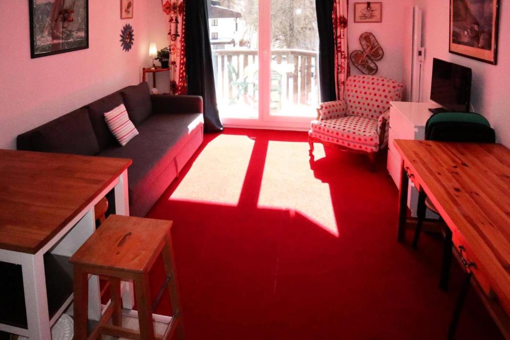 - un salon rouge avec un canapé et une table dans l'établissement Résidence Les Tavaillons - 208 Les Tavaillons Studio pour 4 personnes MAE-8861, aux Orres