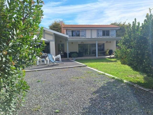 une maison avec une table et des chaises devant dans l'établissement Maison 6 à 8 pers au bord du Lac de Biscarrosse, à Biscarrosse