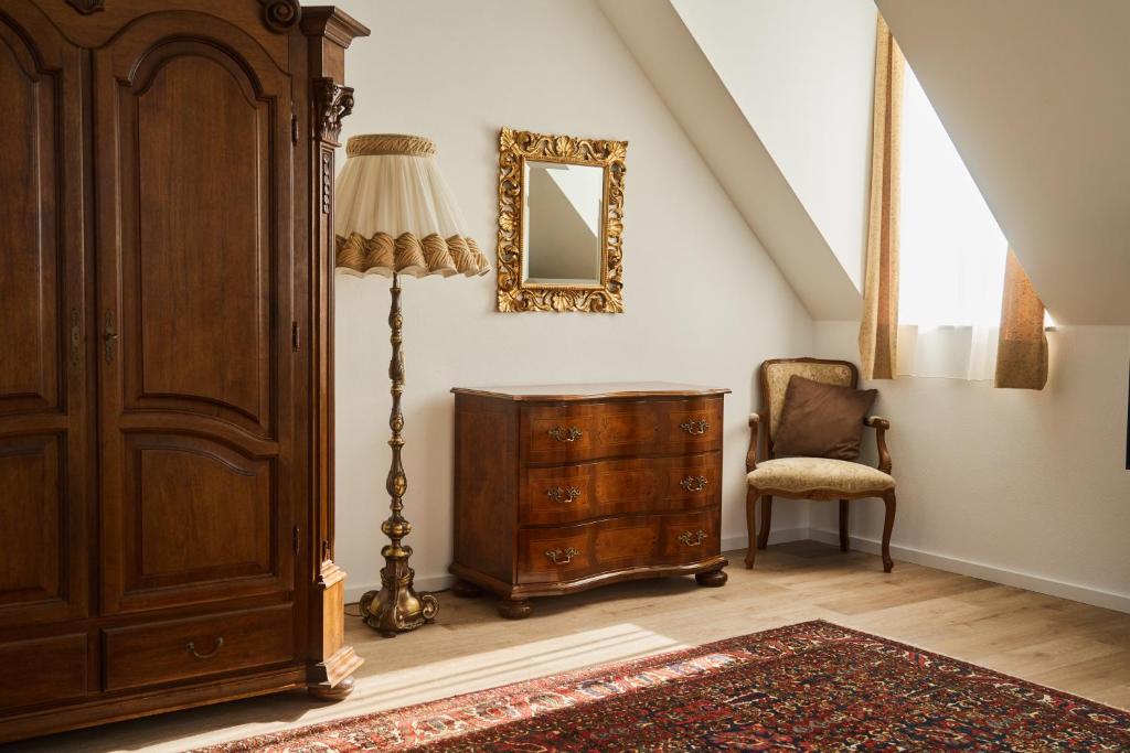 a room with a dresser and a lamp and a chair at Residenz Rosina Salzburg in Salzburg