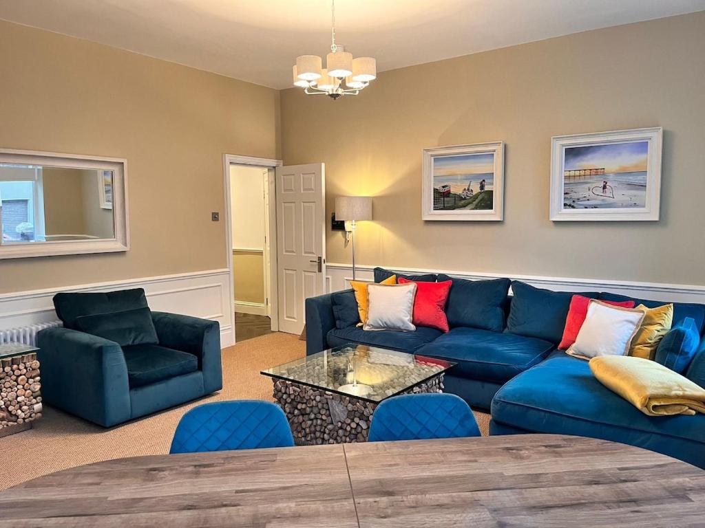 a living room with a blue couch and chairs at Ruby Sands in Saltburn-by-the-Sea