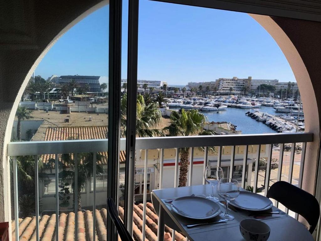 balkon ze stołem i widokiem na port w obiekcie Résidence Port Soleil Bâtiment B3 - Studio Cabine 2 pers. Port Soleil CAP d'AGDE MAE-4424 w Cap d'Agde