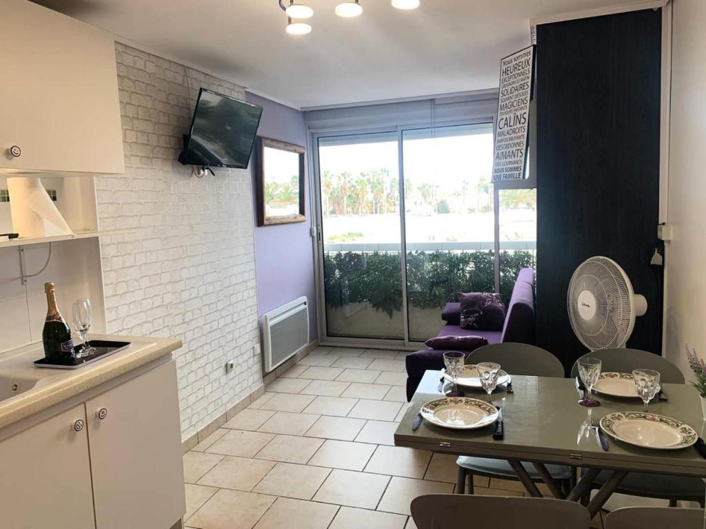 une cuisine et un salon avec une table et des chaises dans l'établissement Résidence Port Soleil Bâtiment B3 - Studio 2 pers. - Résidence Port Soleil MAE-5281, au Cap d'Agde