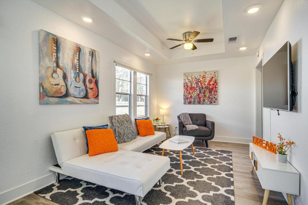 a living room with a couch and a flat screen tv at Charming Gulf Coast Cottage - 1 Mile to the Coast! in Long Beach