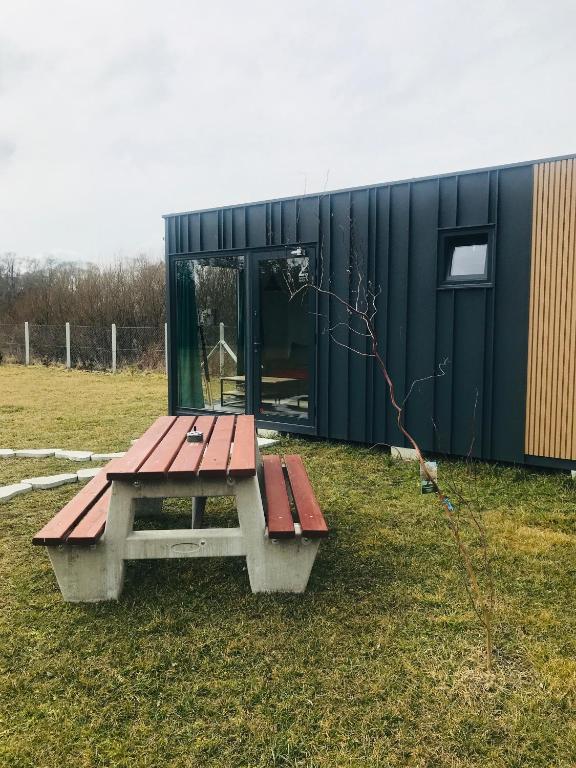 a picnic table in a field next to a building at TinyHouses & Garden in Oravská Poruba