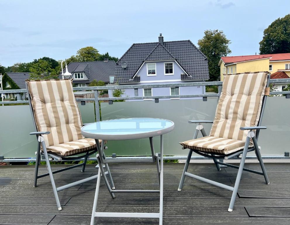 two chairs and a table on a balcony at Küstenkoje Red Balkon und Hund willkommen in Prerow