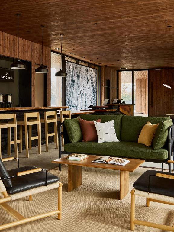 ein Wohnzimmer mit einer grünen Couch und einer Bar in der Unterkunft AutoCamp Sequoia in Three Rivers
