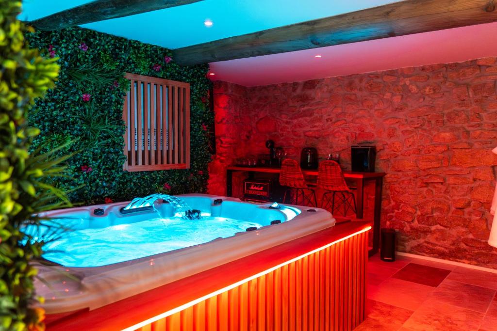 une baignoire jacuzzi dans une chambre aux murs rouges dans l'établissement Love Room l'Eden Secret, à Grans