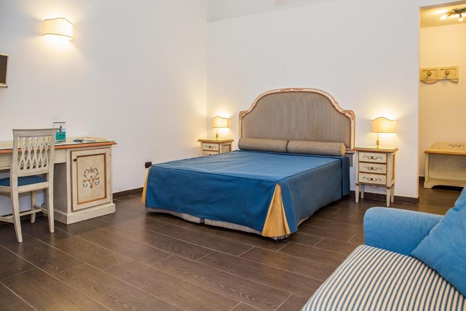 1 dormitorio con 1 cama azul y 1 sofá azul en La Rada B&B, en Bacoli