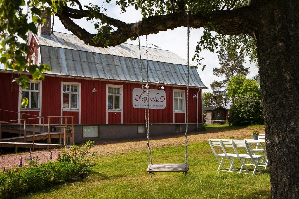une balançoire en face d'une grange rouge dans l'établissement Amalia, à Lemland