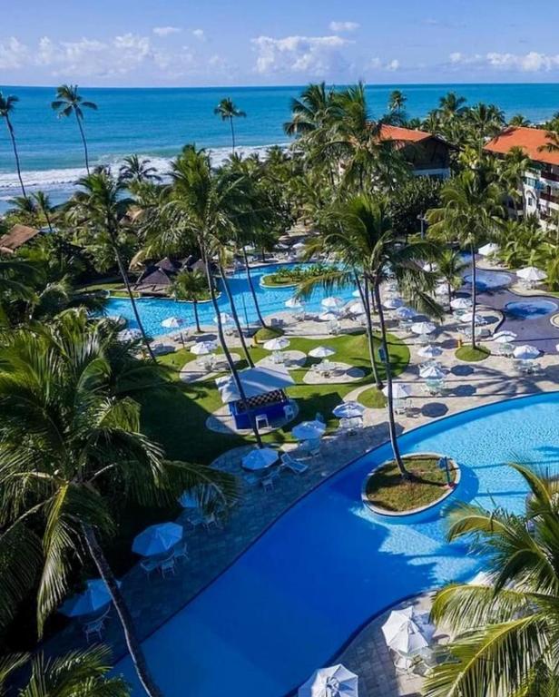 an aerial view of a resort with palm trees and the ocean at Marulhos Resort Studio Master in Porto De Galinhas