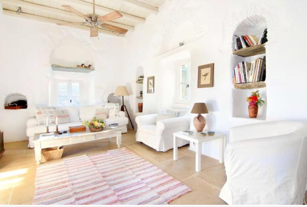 a living room with white furniture and white walls at Aegean Bliss Villa - Hydroussa in Andros