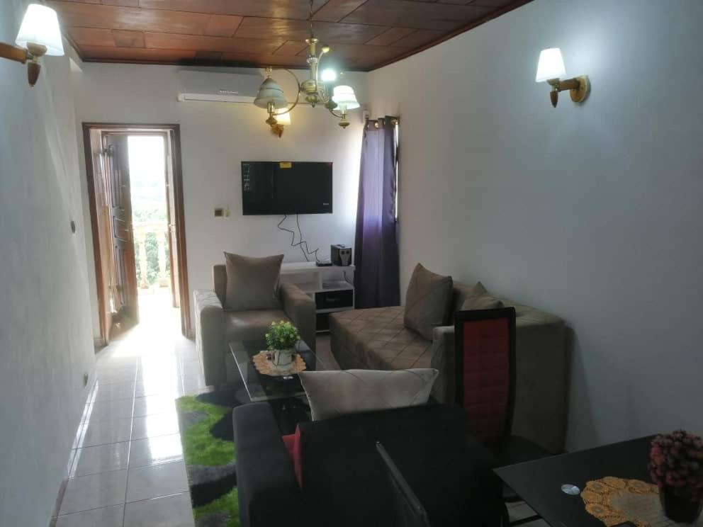 un soggiorno con un divano e un tavolo di studio meublé essos a Yaoundé