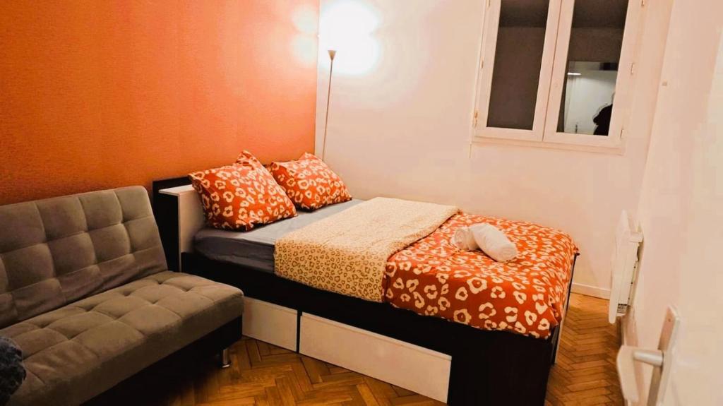 una pequeña habitación con una cama y una silla en Mini-studio avec kitchenette OU chambre confort avec frigo et TV - Parking en option sur résa !, en Chaville