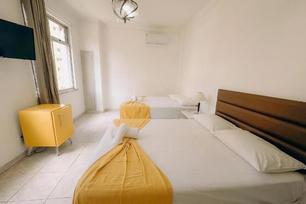 a bedroom with two beds and a yellow cabinet at Apto Amplo e confortável no centro de Salvador in Salvador